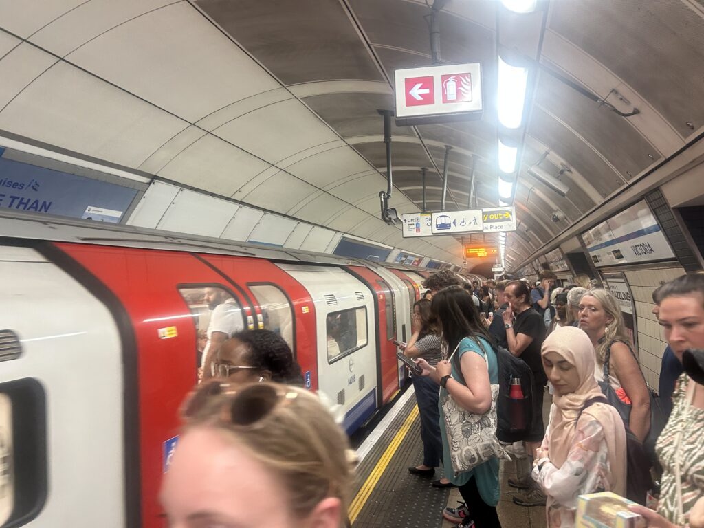 People waiting for a London tube train to stop.