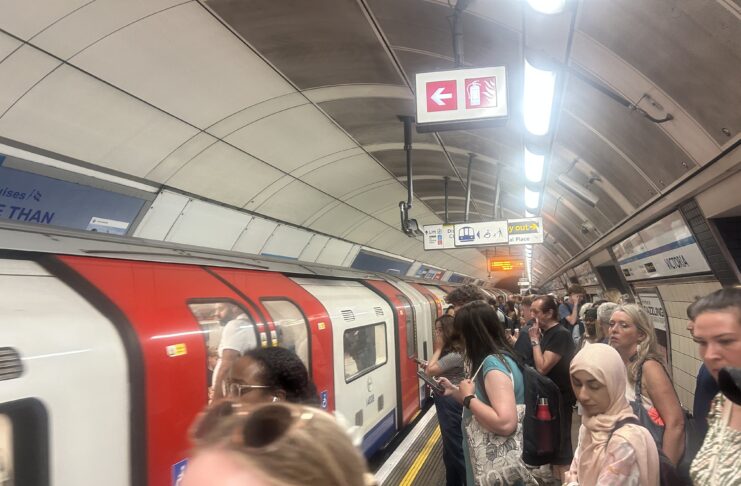 People waiting for a London tube train to stop.