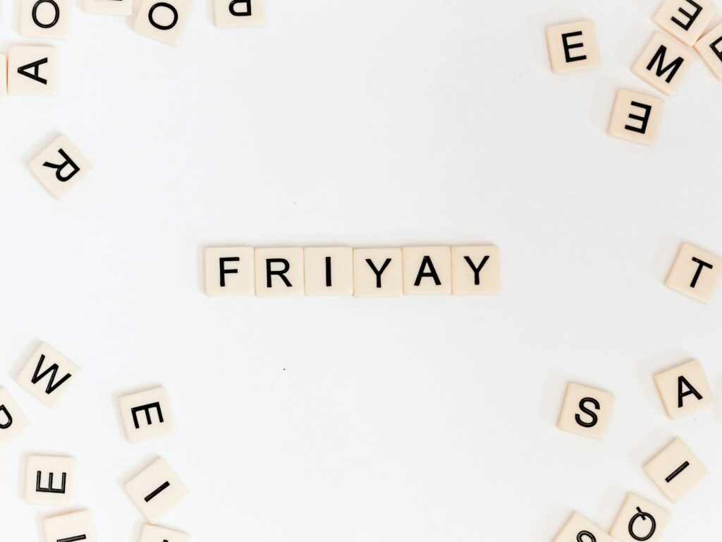 Friyay scrabble pieces on a white surface.