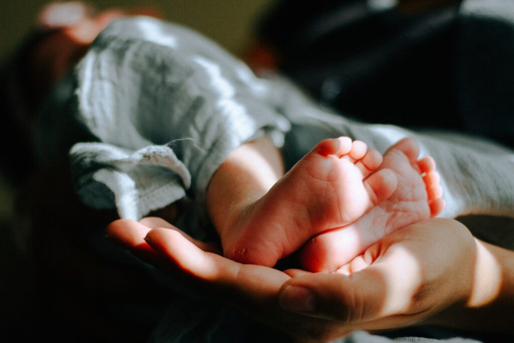 A person holding a baby's feet.