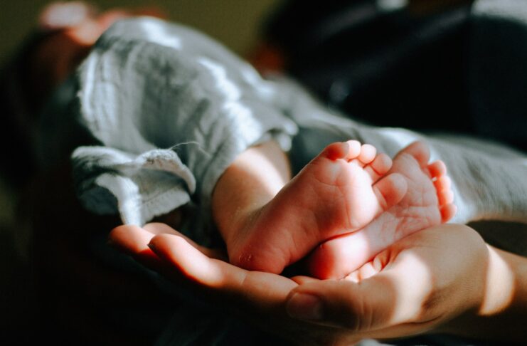 A person holding a baby's feet.