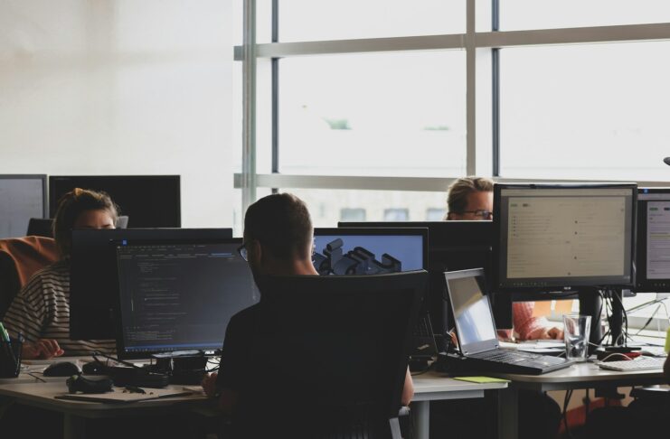 Workers at computers in an open office setting.