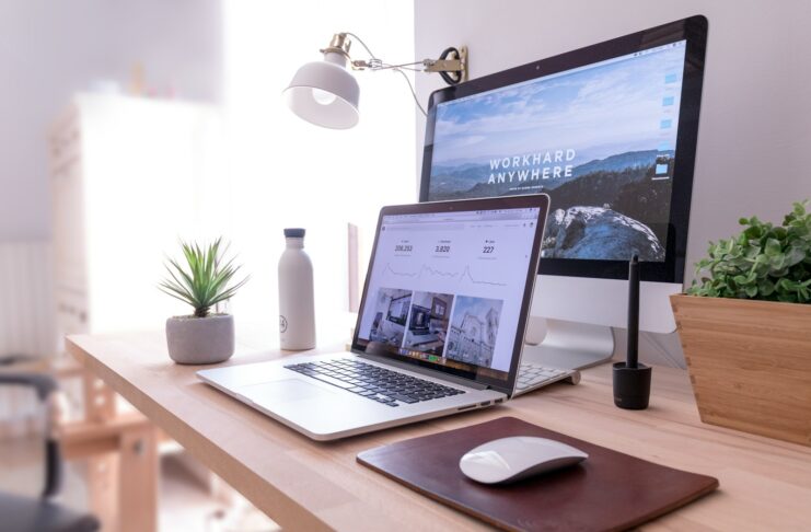 Computers at a desk in a home office setup.