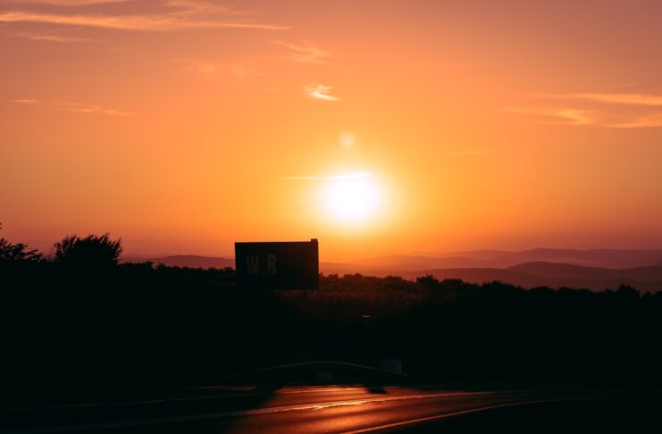 The sun setting, making the sky orange.