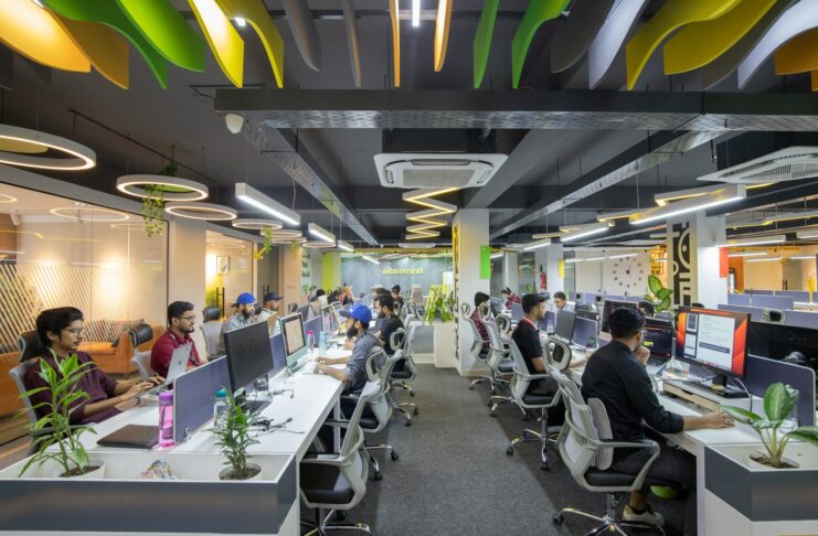 People sitting at desks in a large open-plan office.