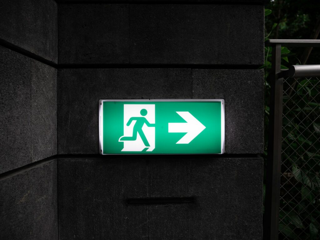 A green and white emergency exit sign.