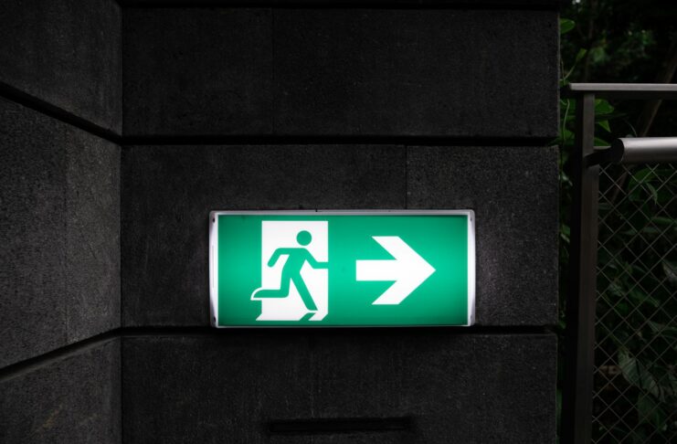 A green and white emergency exit sign.