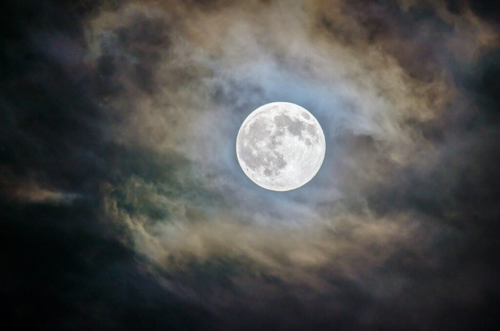 Full moon and grey clouds during nighttime.