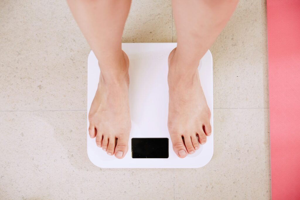 A person weighing themselves on a bathroom scales.