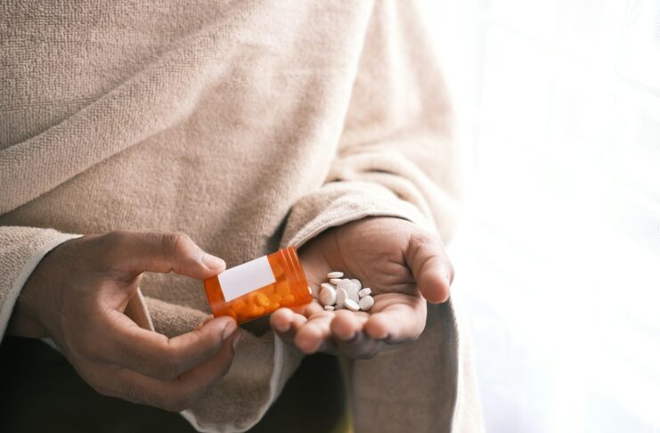 orange and white plastic bottle on white textile
