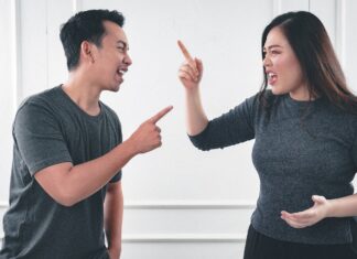 Acas Marks 50 Years as Nearly Half of UK Adults Report Workplace Conflict A man and woman pointing at each other and shouting.