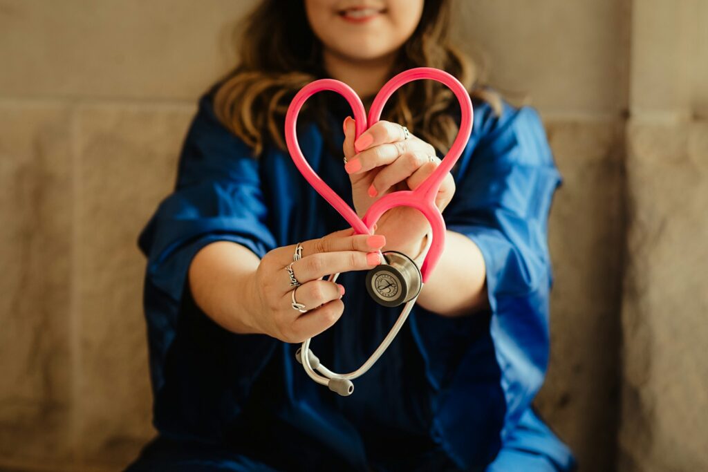 A woman holding a stethoscope in the shape of a love heart.