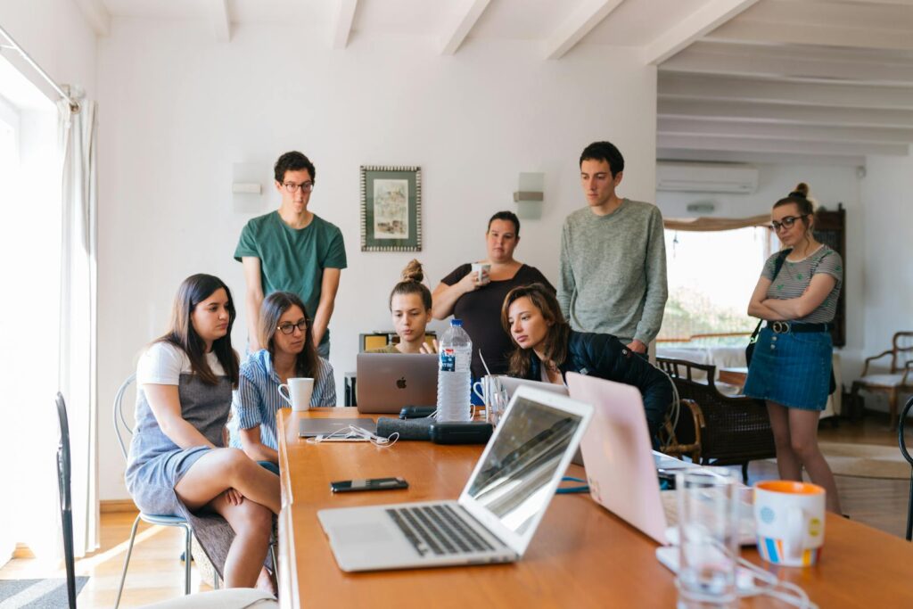 Men and women around a long desk in a modern office setting.