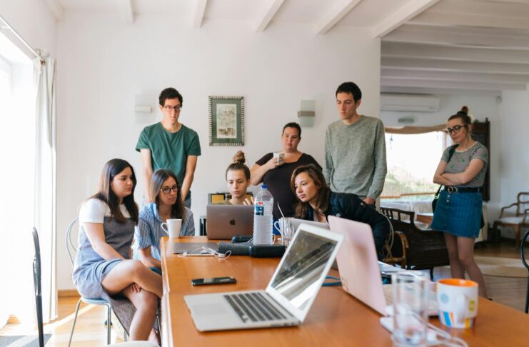 Men and women around a long desk in a modern office setting.