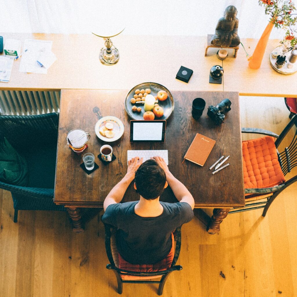 A man works on a laptop in a home setting.