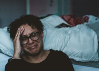 Work Offers a Lifeline To Unpaid Carers – But ‘Nearly Half May Cut Hours or Quit Without Support’ person crying beside bed