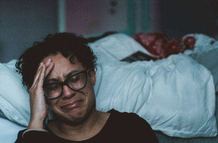 person crying beside bed