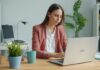 Four Wellbeing Trends Set to Reshape Workforces in 2026 Young woman working on a laptop at a desk.
