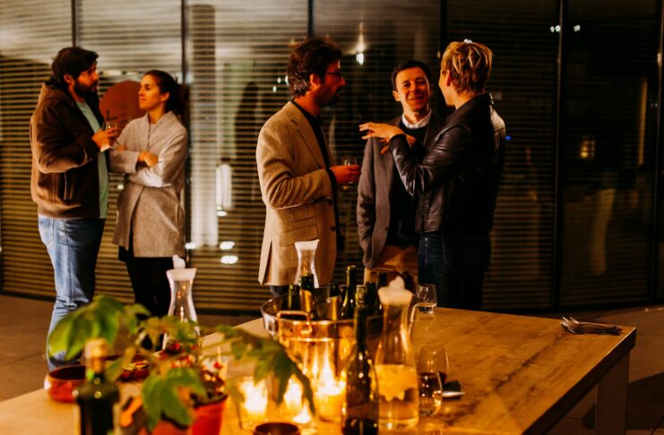 five person standing while talking each other