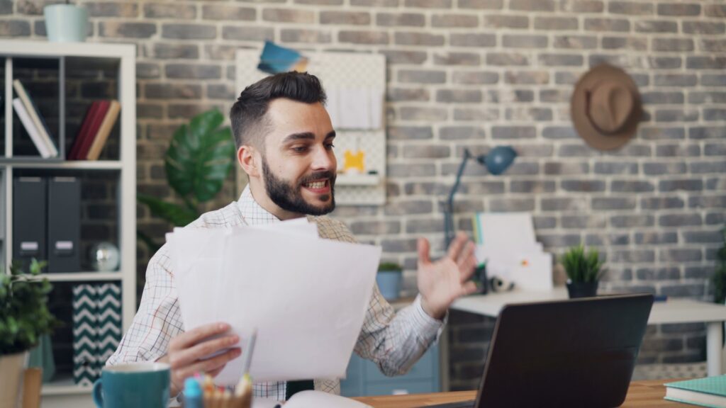 A bearded man working on a laptop.
