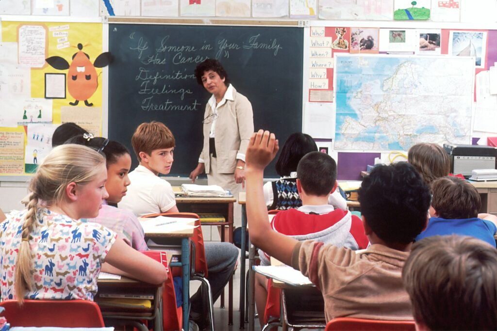 A teacher and pupils in a classroom.