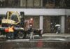 Winter Weather Warnings Raise Safety Concerns for UK Tradespeople Workers with a forklift during snowfall on a city street.